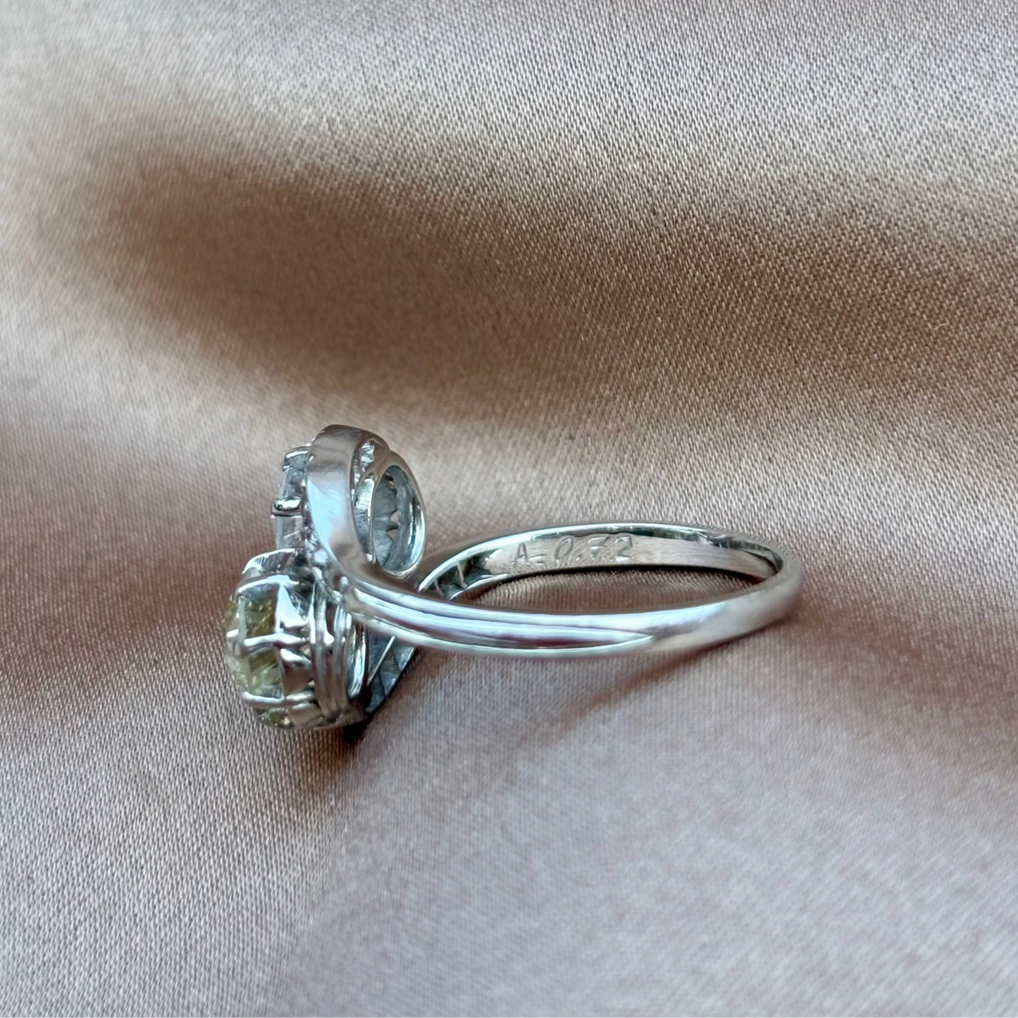 Silver ring with a large gemstone on beige fabric