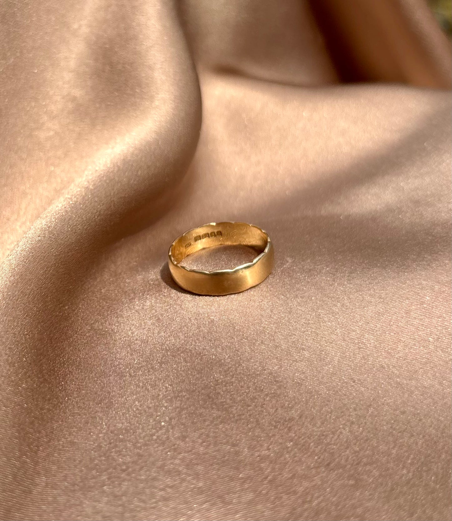 Gold ring on a beige fabric surface