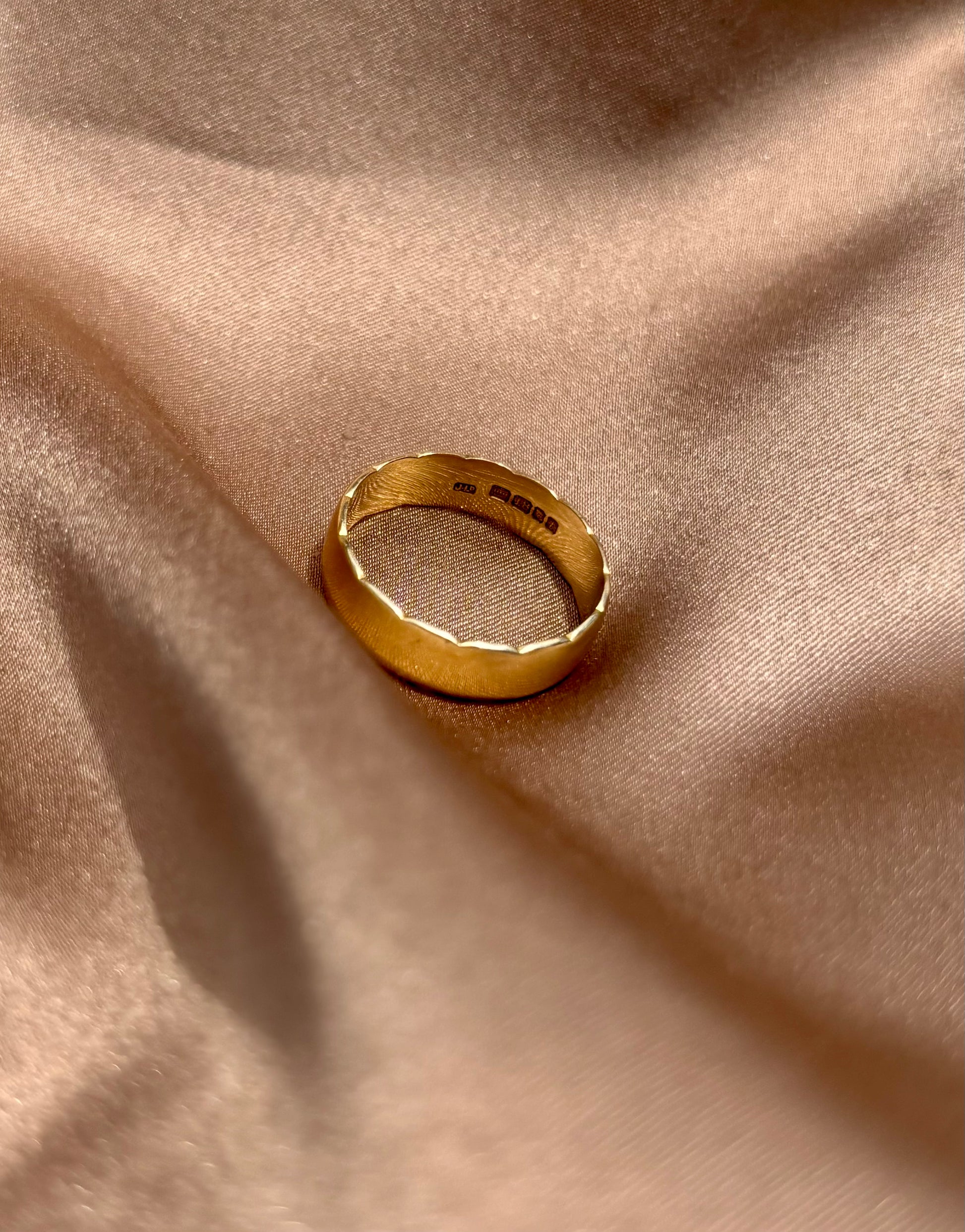 Gold ring on a beige fabric surface