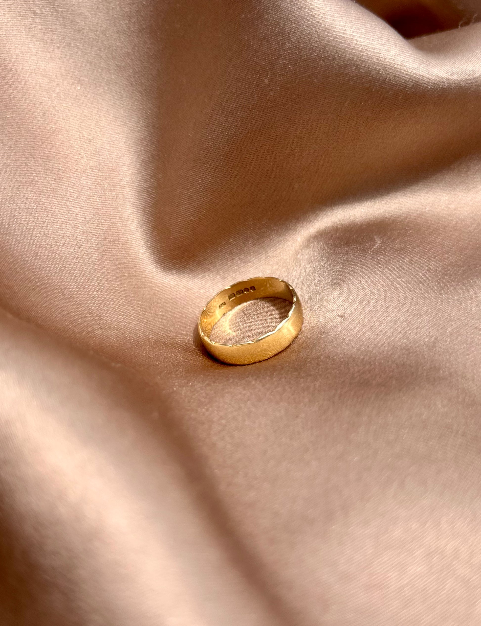 Gold ring on a beige fabric surface