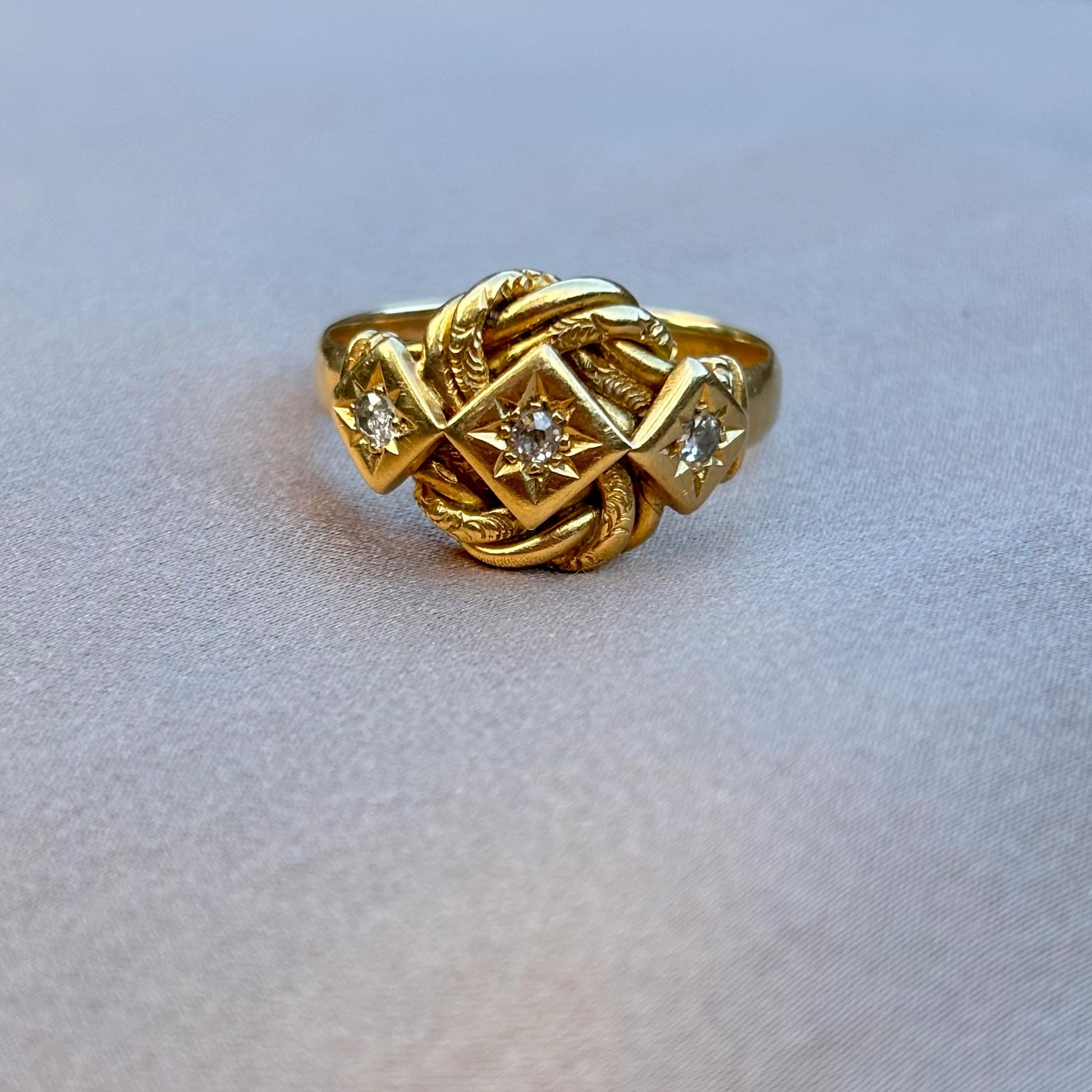Gold ring with intricate design on a light gray background
