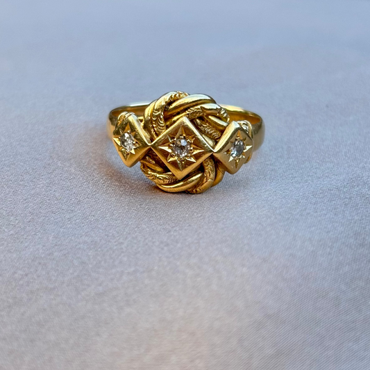 Gold ring with intricate design on a light gray background