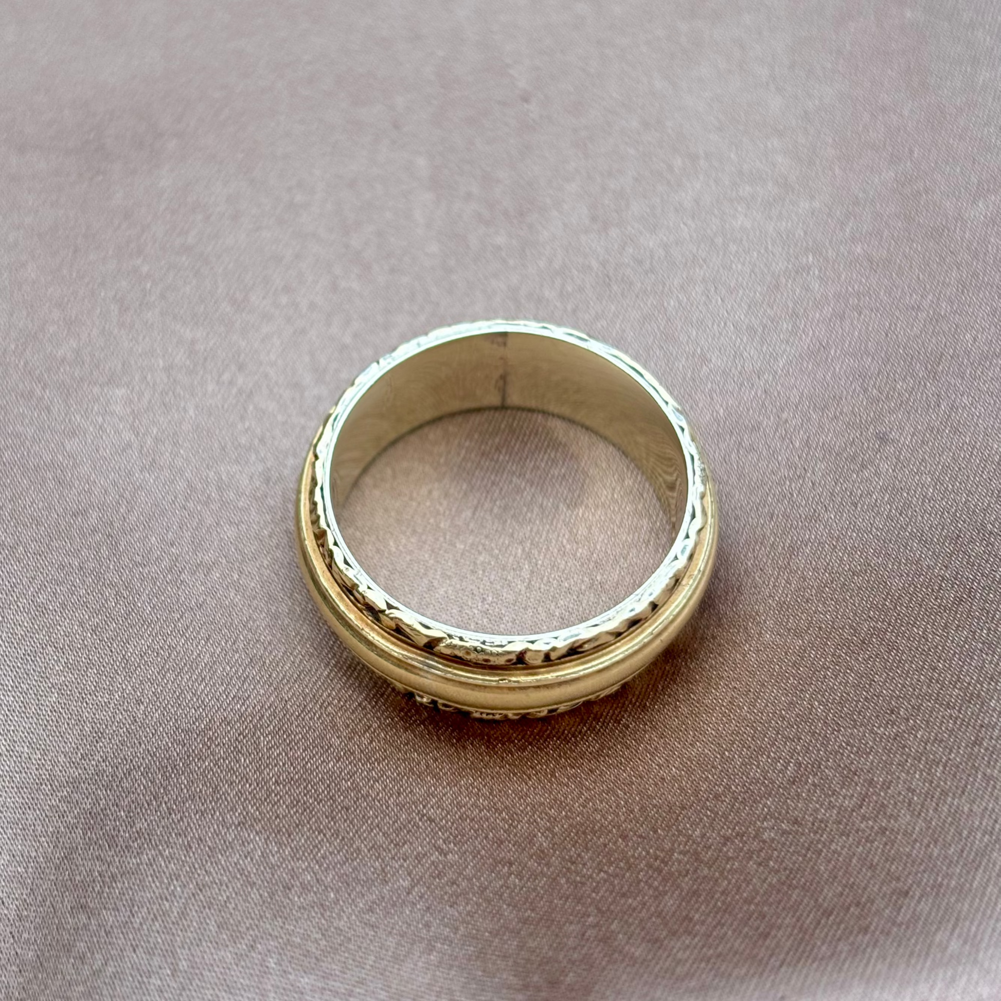 Gold ring on a beige fabric background