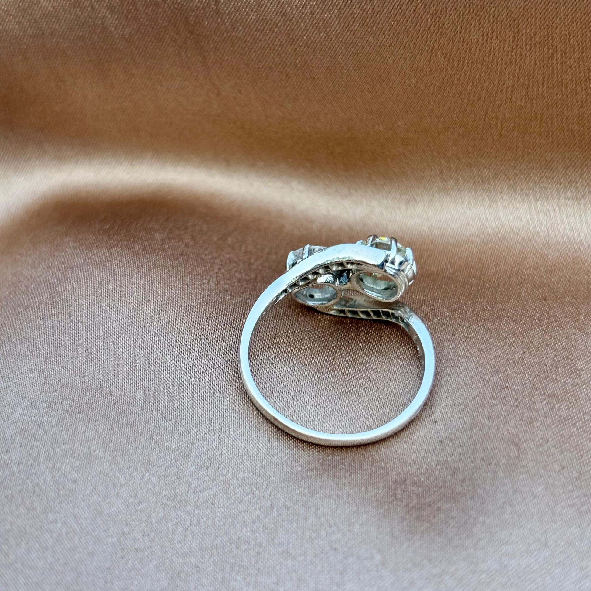 Silver ring with a diamond on a beige fabric background