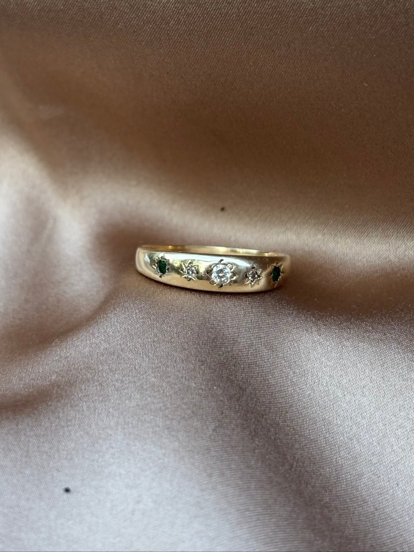 Gold ring with engraving on a soft beige fabric background