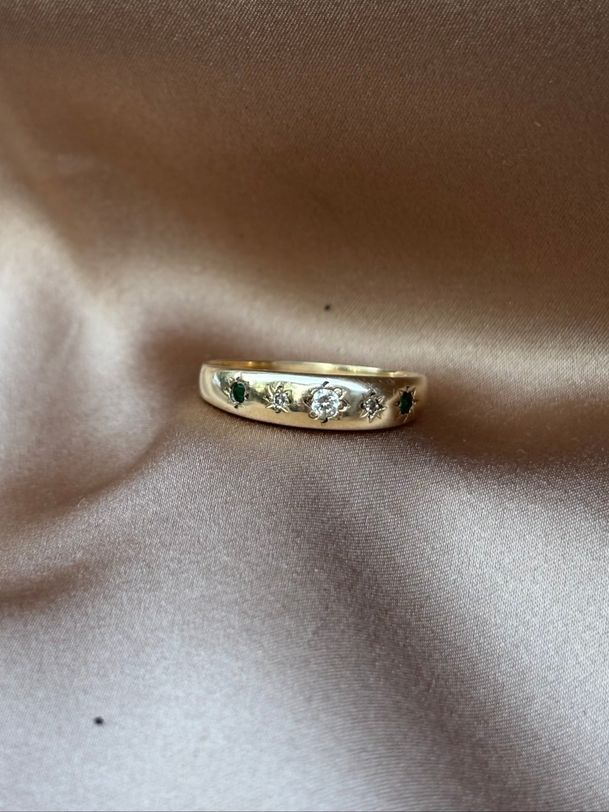 Gold ring with engraving on a soft beige fabric background